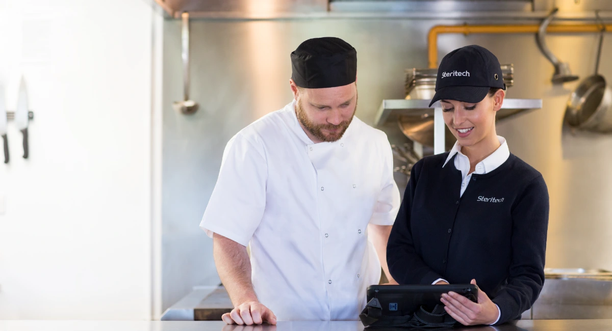 Steritech colleague consulting food service worker